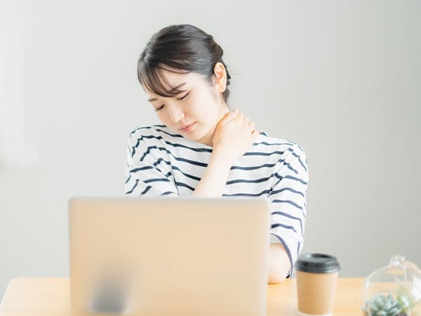 首に痛みを感じている女性